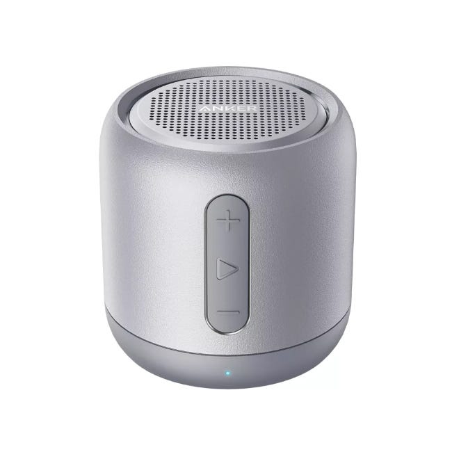 The Soundcore Mini is a compact, cylindrical Bluetooth speaker with a metallic finish and control buttons on the side for volume and playback.