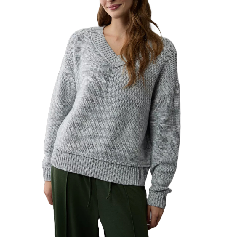A light gray V-neck sweater featuring a relaxed fit with ribbed cuffs and hem, worn over dark green pants.