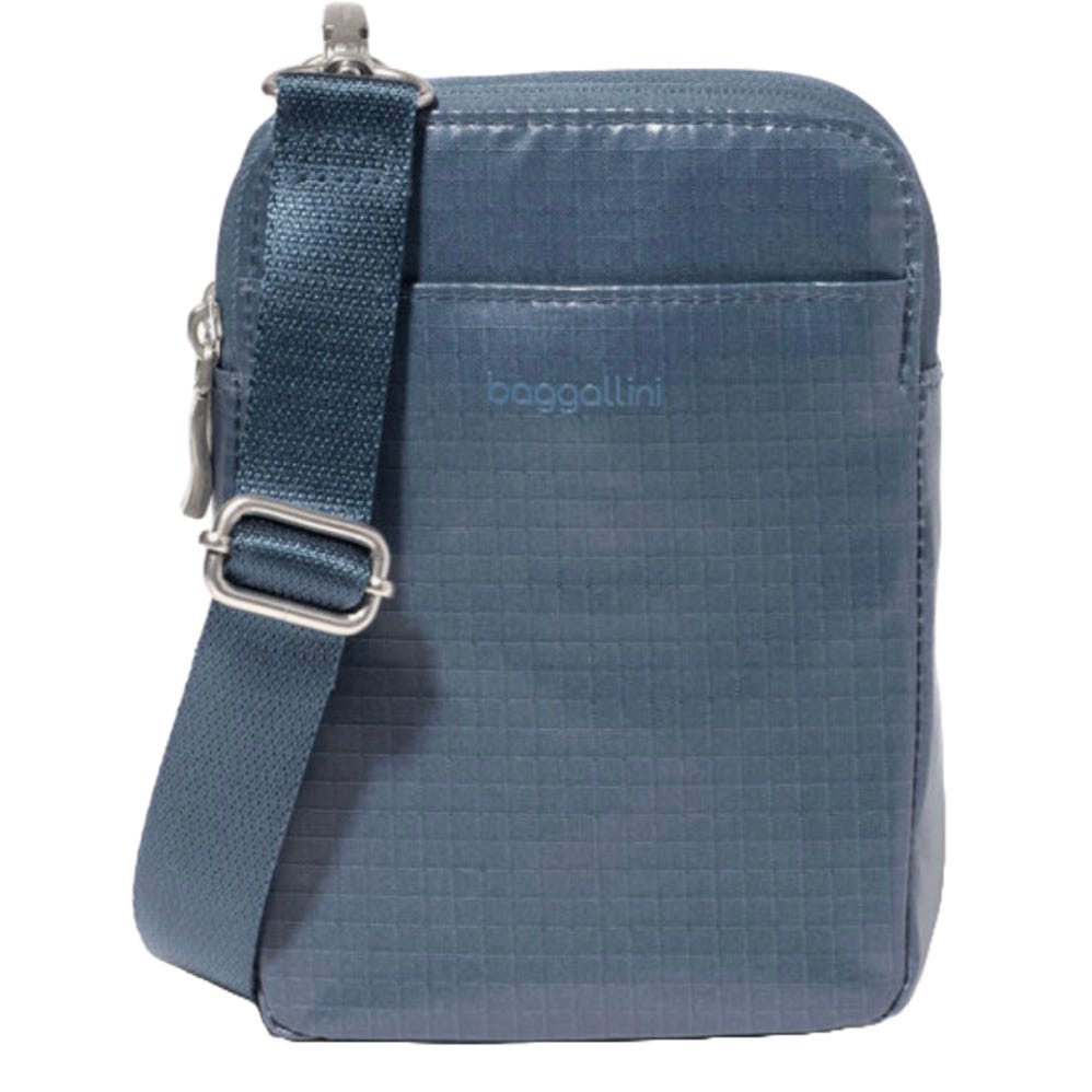 A compact blue crossbody bag with an adjustable strap, featuring a subtle grid pattern and the brand name \“baggallini\“ on the front.