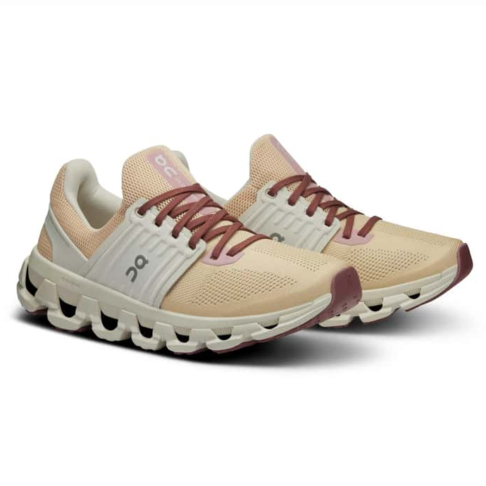 The On Women's Cloudswift 3 AD Shoes are lightweight running sneakers featuring a beige and maroon color scheme, with a cushioned, segmented sole for support and comfort. They have a mesh upper for breathability and maroon laces.