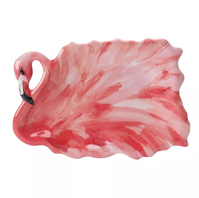 A pink ceramic plate shaped like a flamingo with detailed feathers and a small black and white beak.