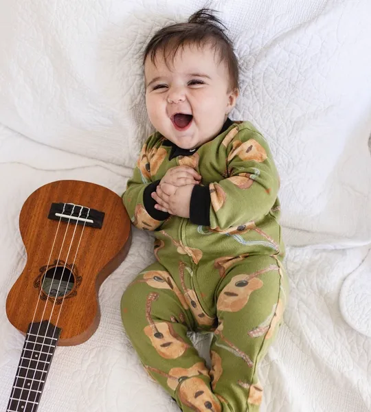 Green baby pajamas featuring a cute acoustic guitar pattern, complete with adorable bear faces and branch designs.