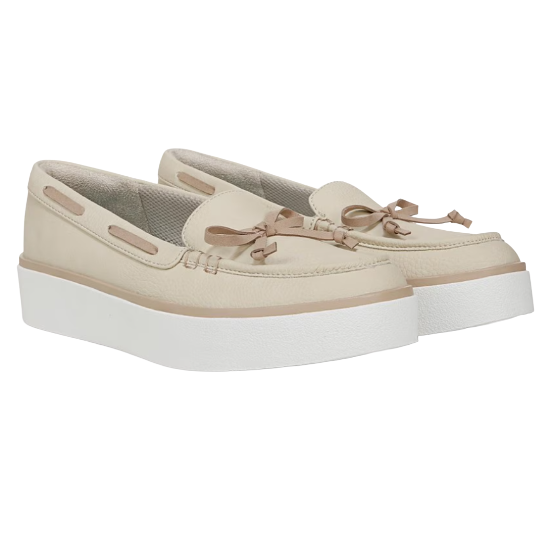 Cream-colored slip-on boat shoes with a platform white sole and decorative bow detailing.