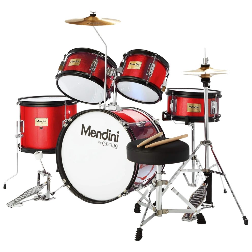 Red Mendini by Cecilio junior drum set with bass drum, snare, toms, cymbals, and a pair of drumsticks on a seat.