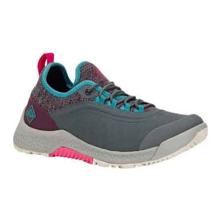 Muck Women's Outscape Lace-Up Sneakers are waterproof with a slip-resistant sole and a grey body featuring teal accents. They have a breathable mesh lining and pull tabs for easy on and off.