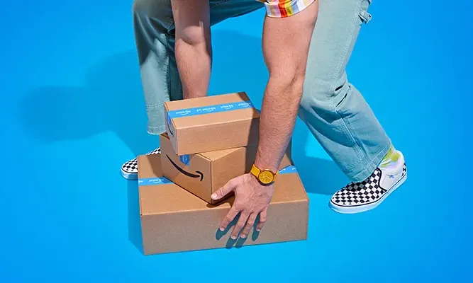 Man with Amazon packages on blue background