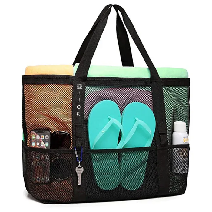 Black mesh tote bag with various pockets containing a smartphone, flip flops, a towel, keys, and sunscreen.