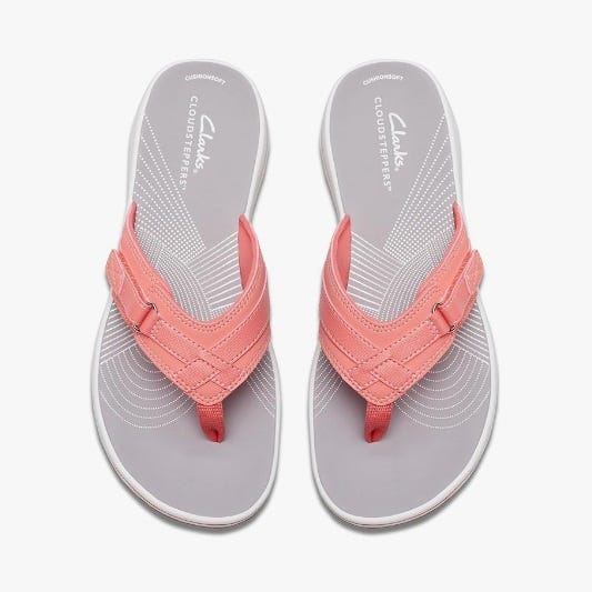 A pair of salmon pink flip-flops with a braided strap design.