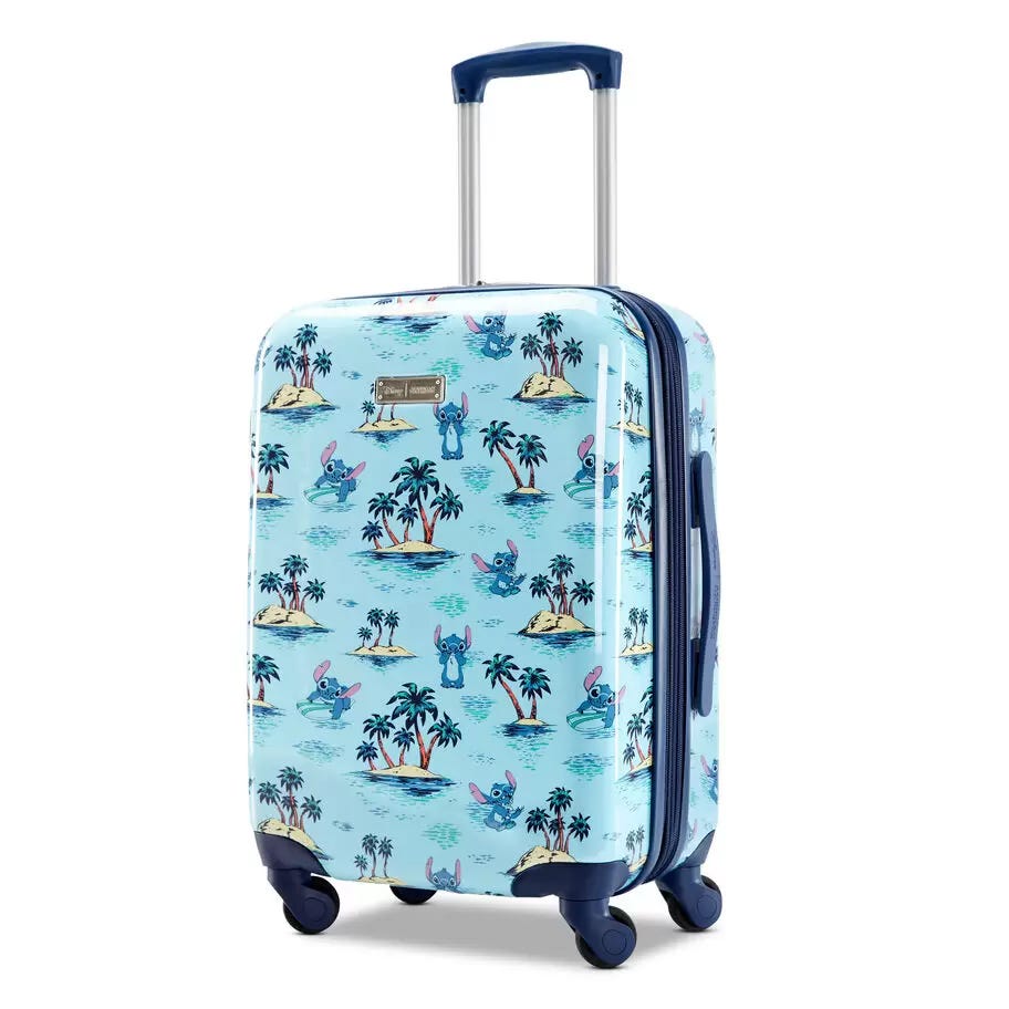 Upright wheeled suitcase with a blue tropical print featuring palm trees and a stylized animal character.