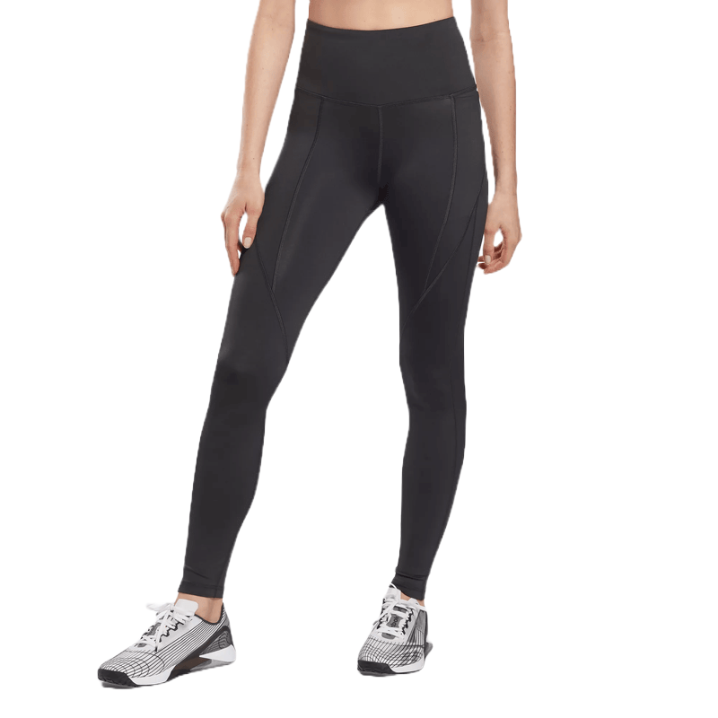 Reebok high-rise leggings feature a sleek, black design with subtle seam detailing. They're paired with stylish, black-and-white athletic shoes.