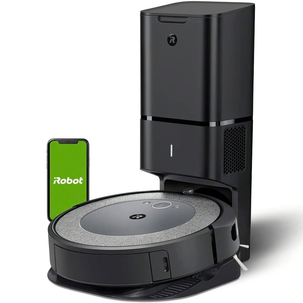 iRobot Roomba robot vacuum with charging station and a smartphone displaying the iRobot app.