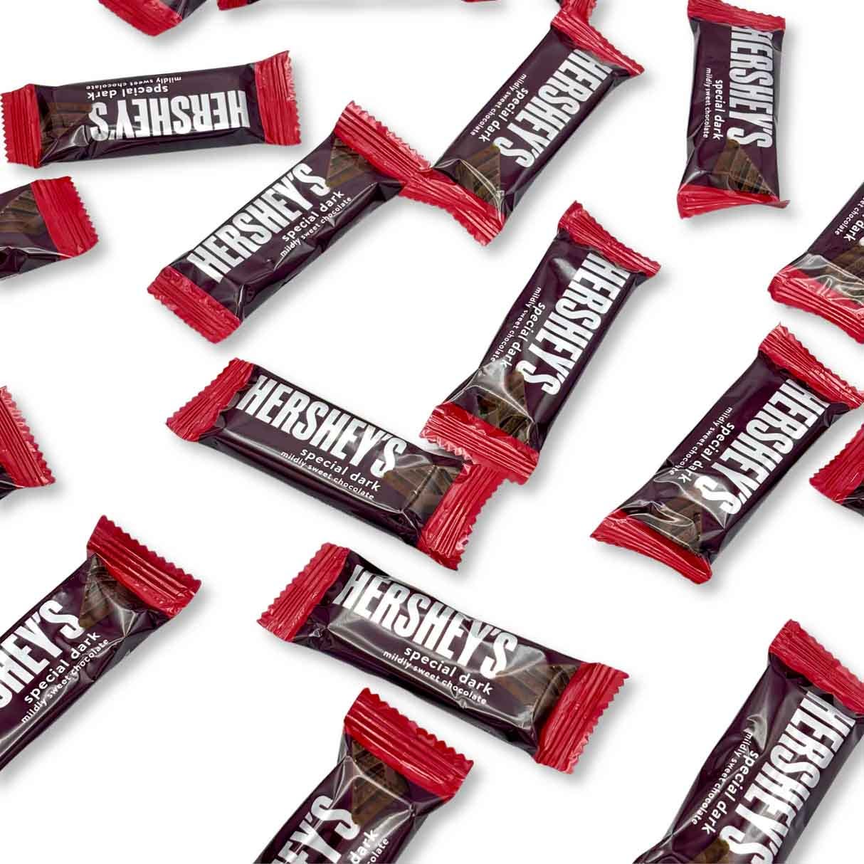 Hershey's Special Dark Chocolates, individually wrapped in dark packaging with red ends, are shown scattered. They feature a bold white logo and contain mildly sweet dark chocolate.