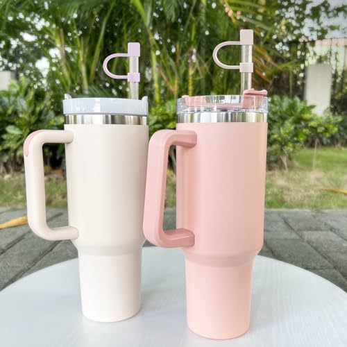 Two insulated tumblers with handles, one white and one pink, each featuring a silicone straw topper with an integrated straw holder loop.