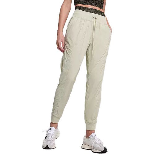 Light green joggers with an elastic drawstring waistband, side pockets, and cuffed ankles, paired with white sneakers.