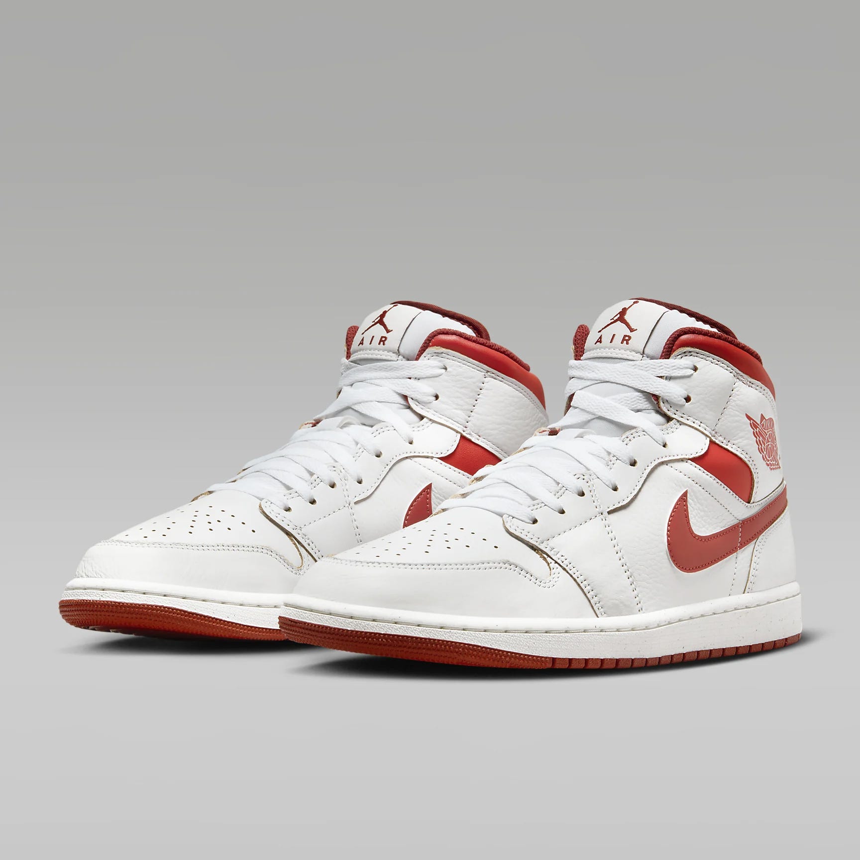 A pair of white and red high-top sneakers with prominent swoosh logos on the sides.