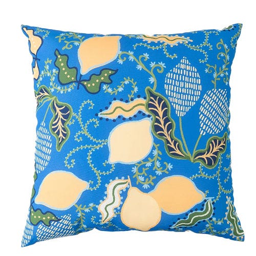A square decorative pillow with a vibrant blue background featuring a pattern of lemons and leaves in shades of yellow, green, and white.