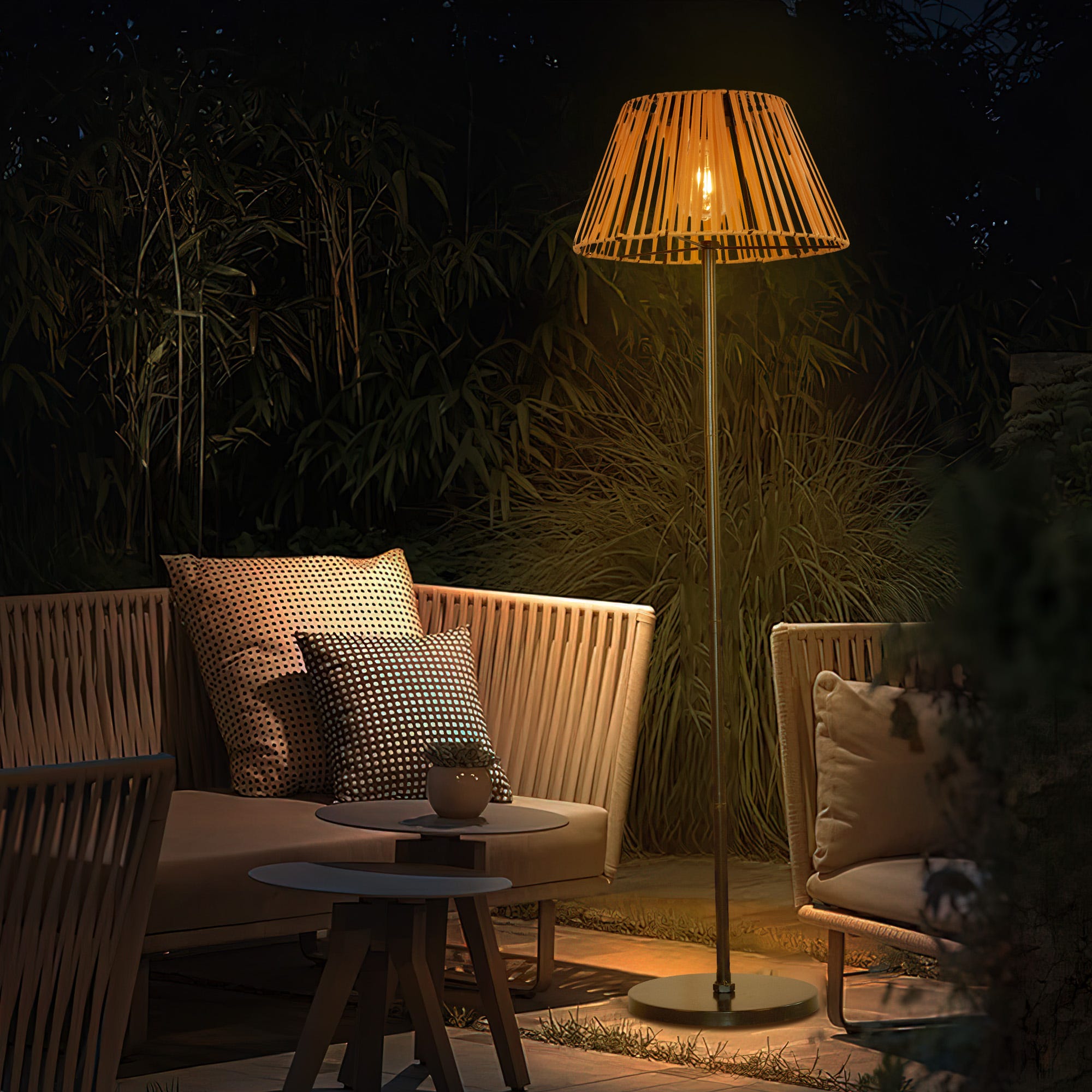 Outdoor furniture including a two-seat sofa with cushions, a side table, and a floor lamp with a warm light.