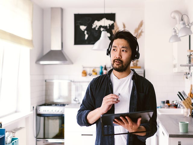 Man standing in his kitchen and learning a language with Berlitz Nicaragua on his tablet