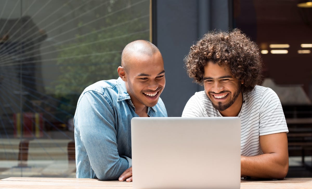 Two men in front of a laptop reading the Privacy policy on Berlitz Nicaragua's website