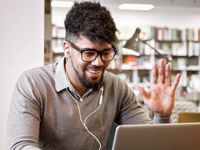 Man in headphones waving at his instructor at the beginning of his online language class with Berlitz Nicaragua