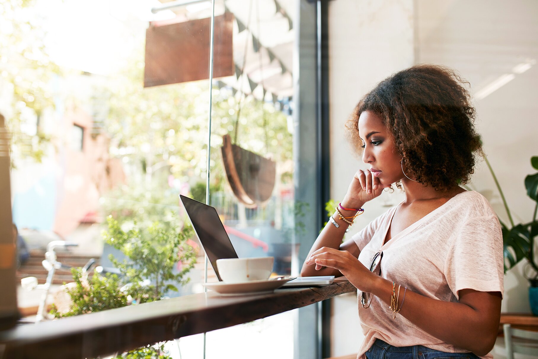 Woman in front of a window learning a language online on her laptop with Berlitz Nicaragua