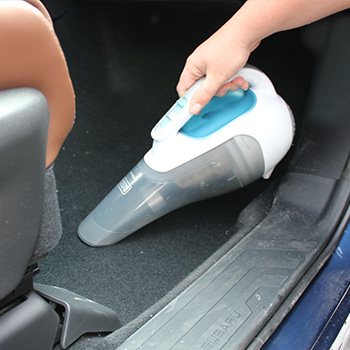handheld vacuum cleaning the car crumbs