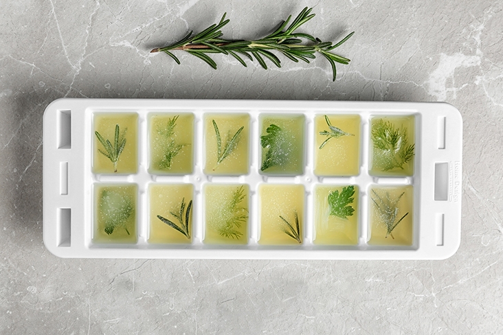 Herbs that are frozen in an ice cube tray.