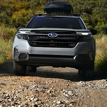 A 2025 Subaru Forester driving toward the camera on an off-road trail.