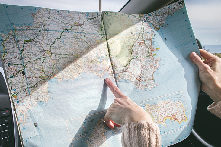 Woman's hand navigating a map in the car