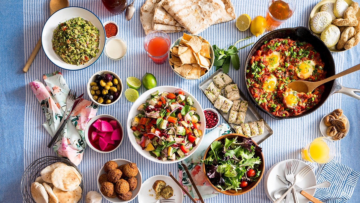 A dining table featuring Mediterranean and Middle Eastern food 