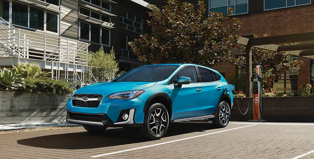 A 2019 Subaru Crosstrek Hybrid in exclusive Lagoon Blue Pearl, plugged into a charging station