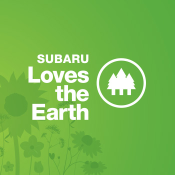 Subaru Loves the Earth logo with white lettering on a green background. To the right of the words “Subaru Loves the Earth” is an illustration of three evergreen trees enclosed in a circle.