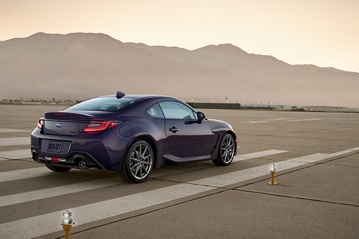 A shiny 2025 Subaru BRZ Series.Purple is parked on cement with mountains in the background.