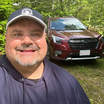 Mark Grady is taking a selfie with his 2023 Subaru Forester Touring.