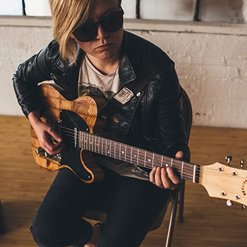 model playing guitar made of salvaged wood