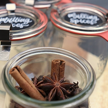 Glass jars labeled “Mulling Spices” that contain cinnamon sticks.