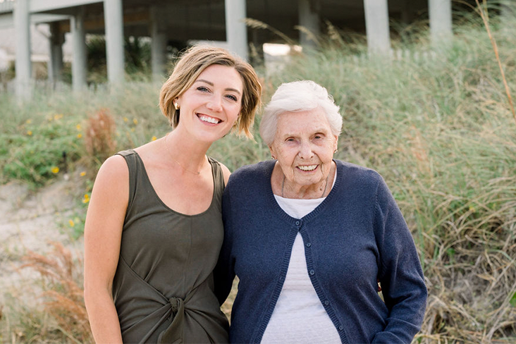 Writer Kate Bernot is standing next to her grandmother. They each have one arm around the other's back and are smiling.