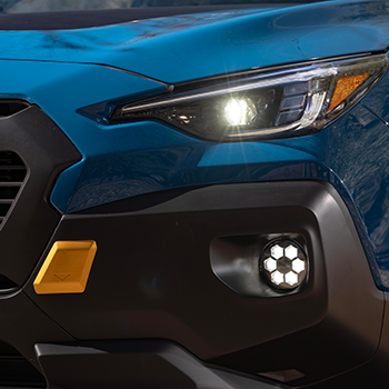 Closeup of a Subaru Crosstrek Wilderness headlight and LED fog light that picks up design elements from the grille.