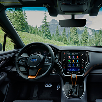 Interior shot of a Subaru Outback Wilderness that shows the steering wheel and STARLINK multimedia touchscreen.