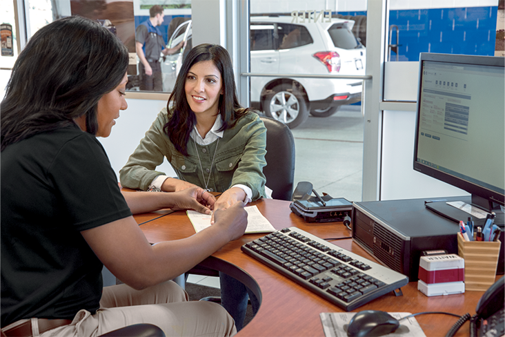 A financial professional and a customer are sitting at a desk going over paperwork