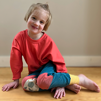 A young female child wearing Peace House Studio clothing.