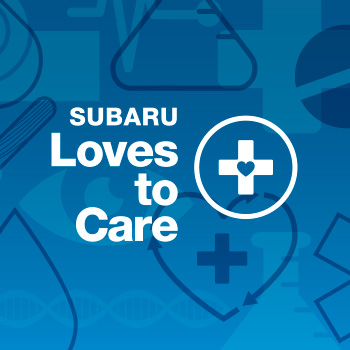 Subaru Loves to Care logo in white lettering on a blue background. To the right of the words “Subaru Loves to Care” is an illustration of a cross with a heart in the center, and it is enclosed in a circle.