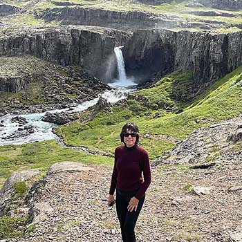Peter Scott’s wife with Folaldafoss waterfall cascading in the distance behind her.
