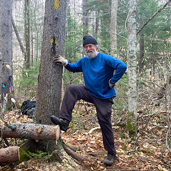 Smith leaning against a tree, smiling.