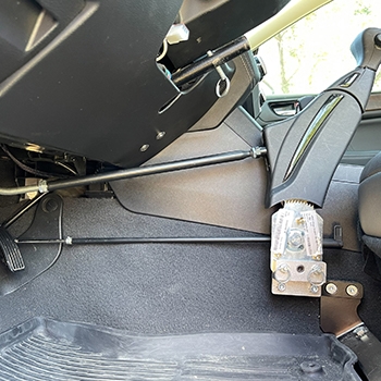 Side view of the Veigel push/pull mechanical hand control with attachments to the brake and accelerator pedals of the Subaru Outback.