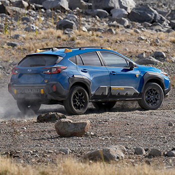 A Subaru Crosstrek Wilderness is driving through rough terrain.