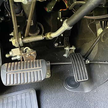 Closeup view of how the Veigel push/pull mechanical hand control is attached to the modified Subaru Outback vehicle’s pedals.