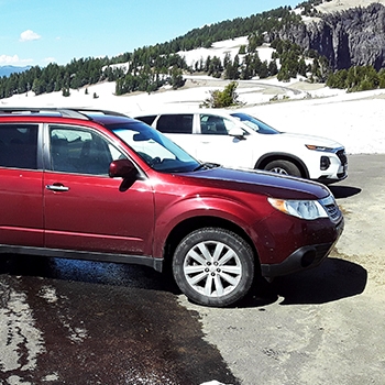  J.R. Wilhite’s 2012 Forester in a parking lot with a snow-capped mountain range and evergreens in the background.