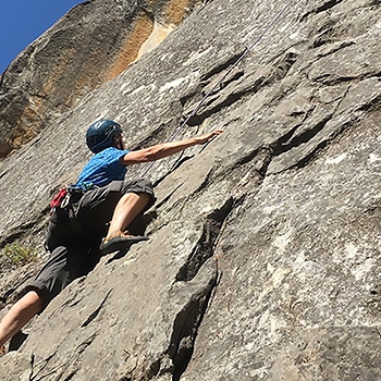 Dierdre Wolownick, seen from below, climbing up a steep rockface.
