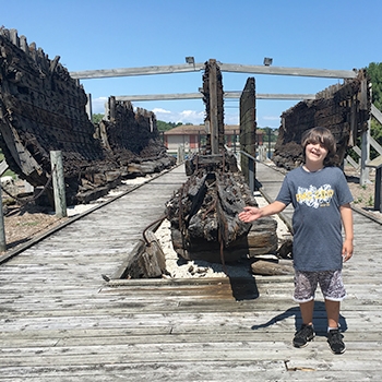 Harry Fitzgerald in front of the Lottie Cooper schooner